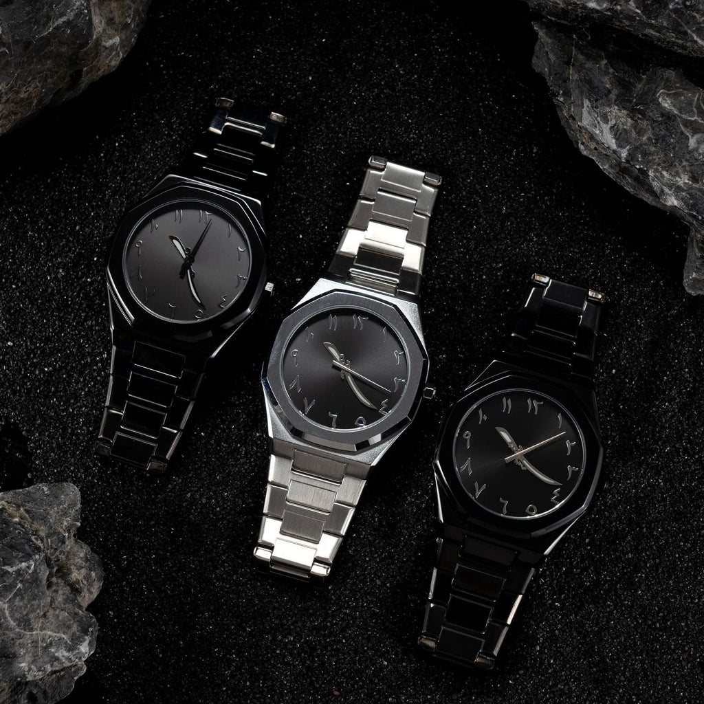 Men's silver and black business casual watch with steel bracelet and analogue dial on a wrist.