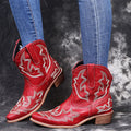 Blue women's Western cowgirl boots with embroidery detail, low wedge heel, and pointed toe.