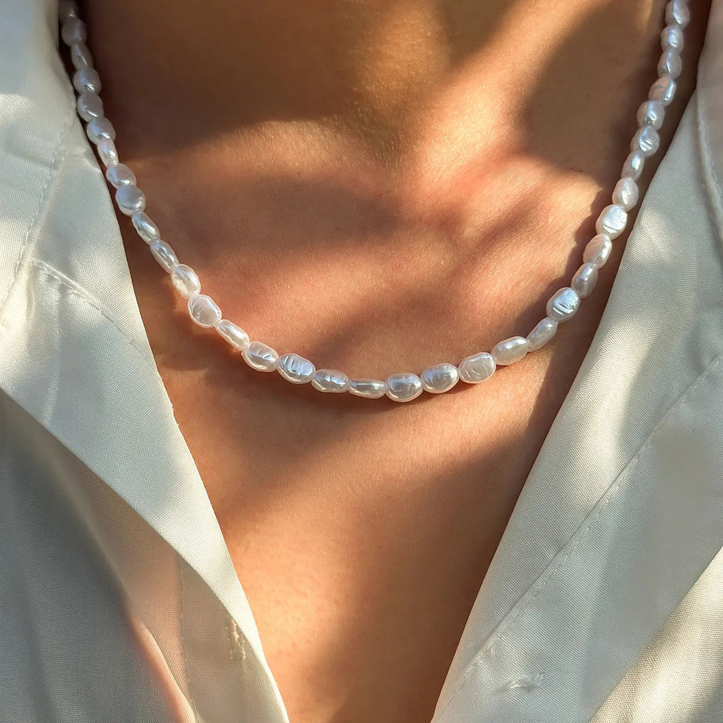 White U-shaped men's imitation pearl necklace with shellfish pendant on clavicle