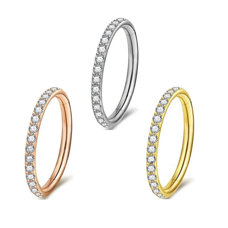 Stainless steel seamless nose ring with a small diamond on the front, shown in a gold finish.