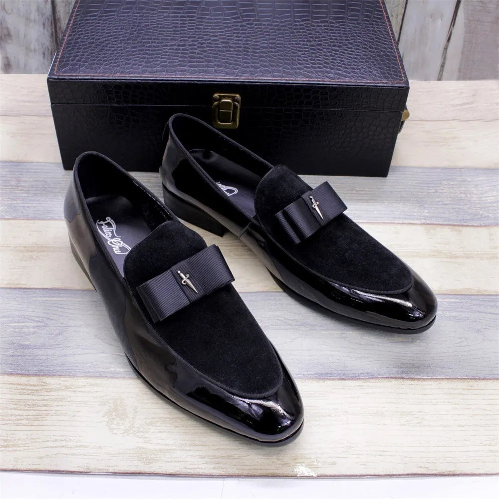 Men's glossy black patent leather low-top shoes featuring a gold tassel detail on a white background.