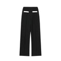 Women's casual suit set with a beaded leather round neck top and high-waisted trousers on a model.
