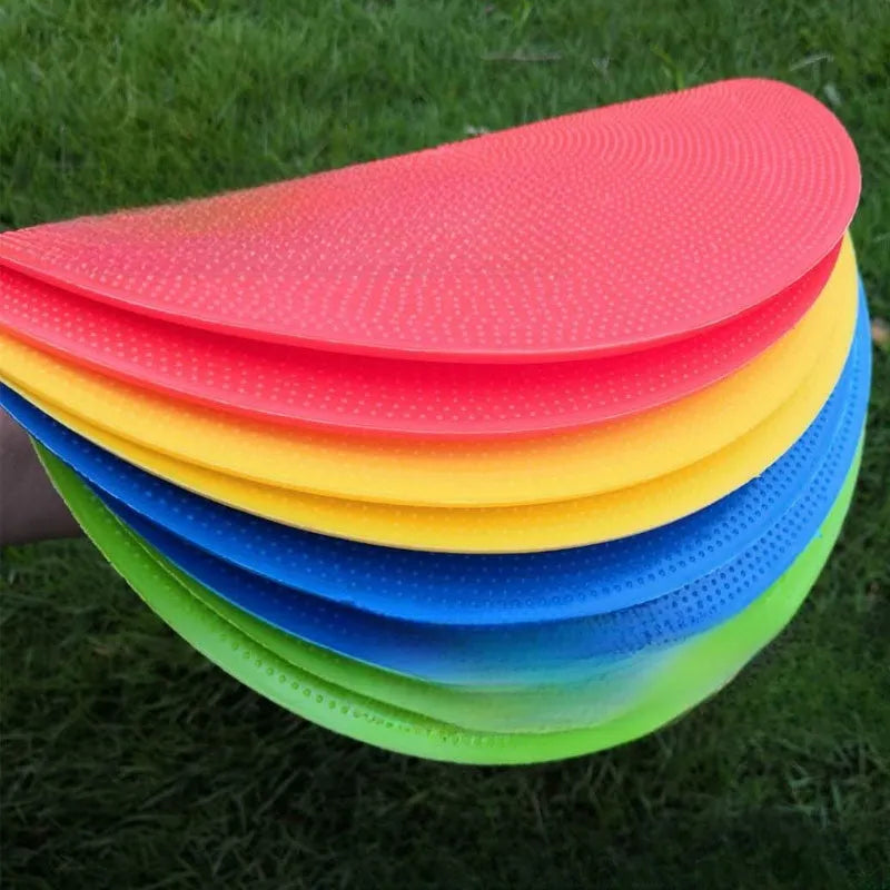 Yellow TPE football training landmark pad, 23cm diameter flat disc on grass.