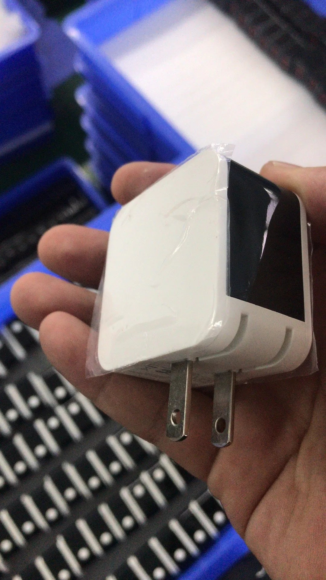 Black dual USB fast charger with digital display showing charging current, plugged into a UK wall socket.