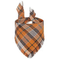 Plaid triangle dog bandana with tassel edges in autumn colours like brown, green, and orange.