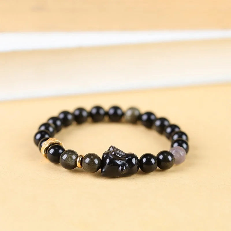 Handmade obsidian bracelet with lying rabbit charm, grey agate beads and brass metalwork in national style