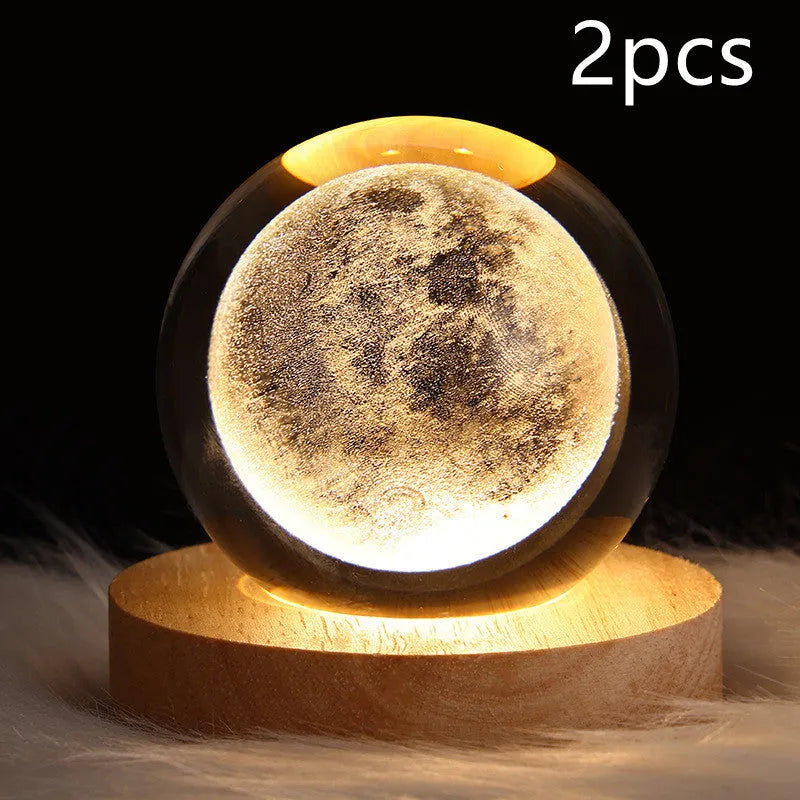 LED galaxy crystal ball night light with 3D planet designs on a table