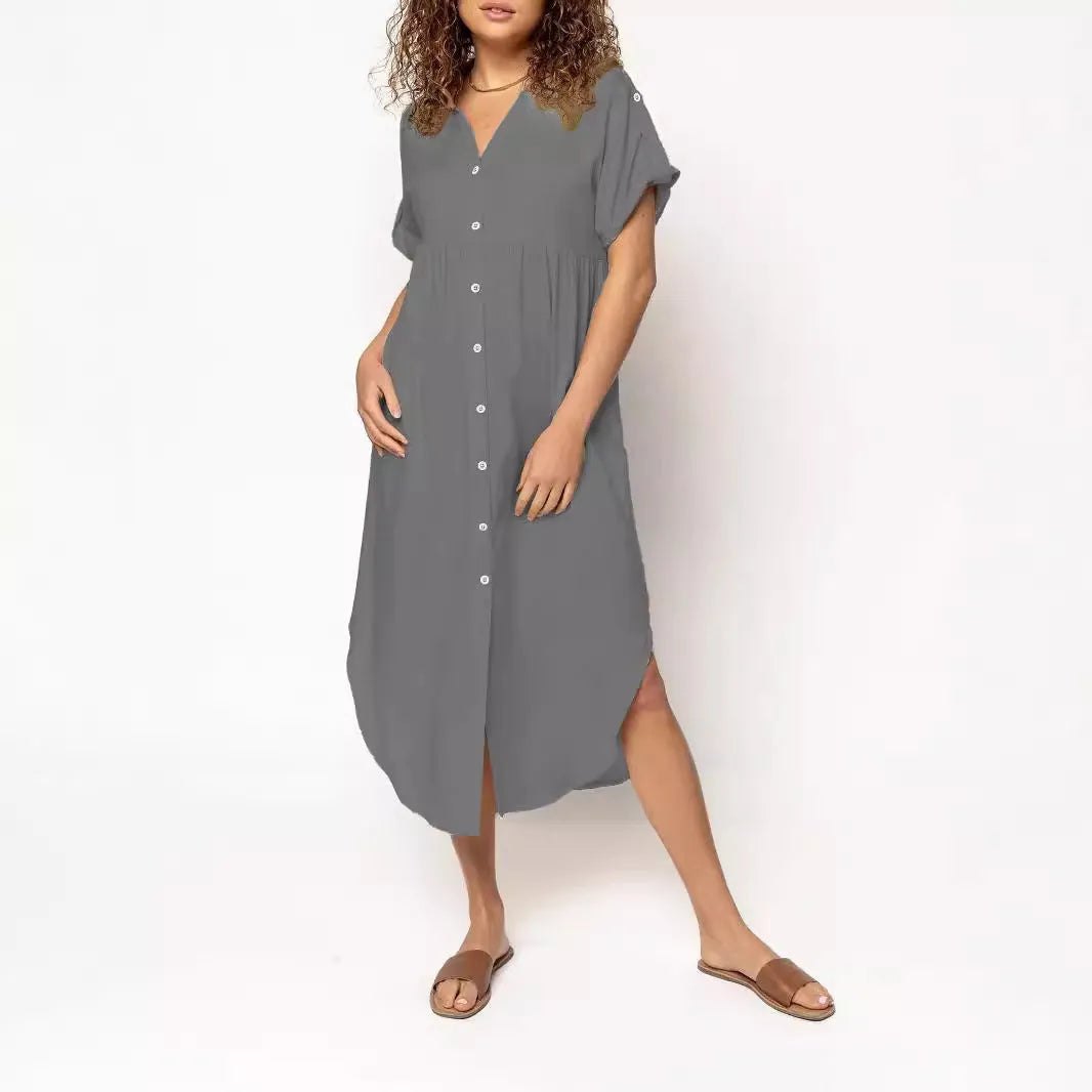 A woman wearing a loose-fitting, solid-colour midi dress with a button-down front and regular sleeves.