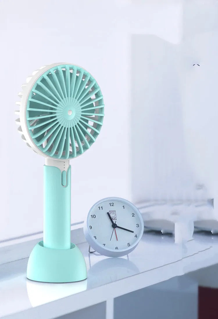 Blue handheld USB electric fan with speed control buttons and oscillation function on desktop