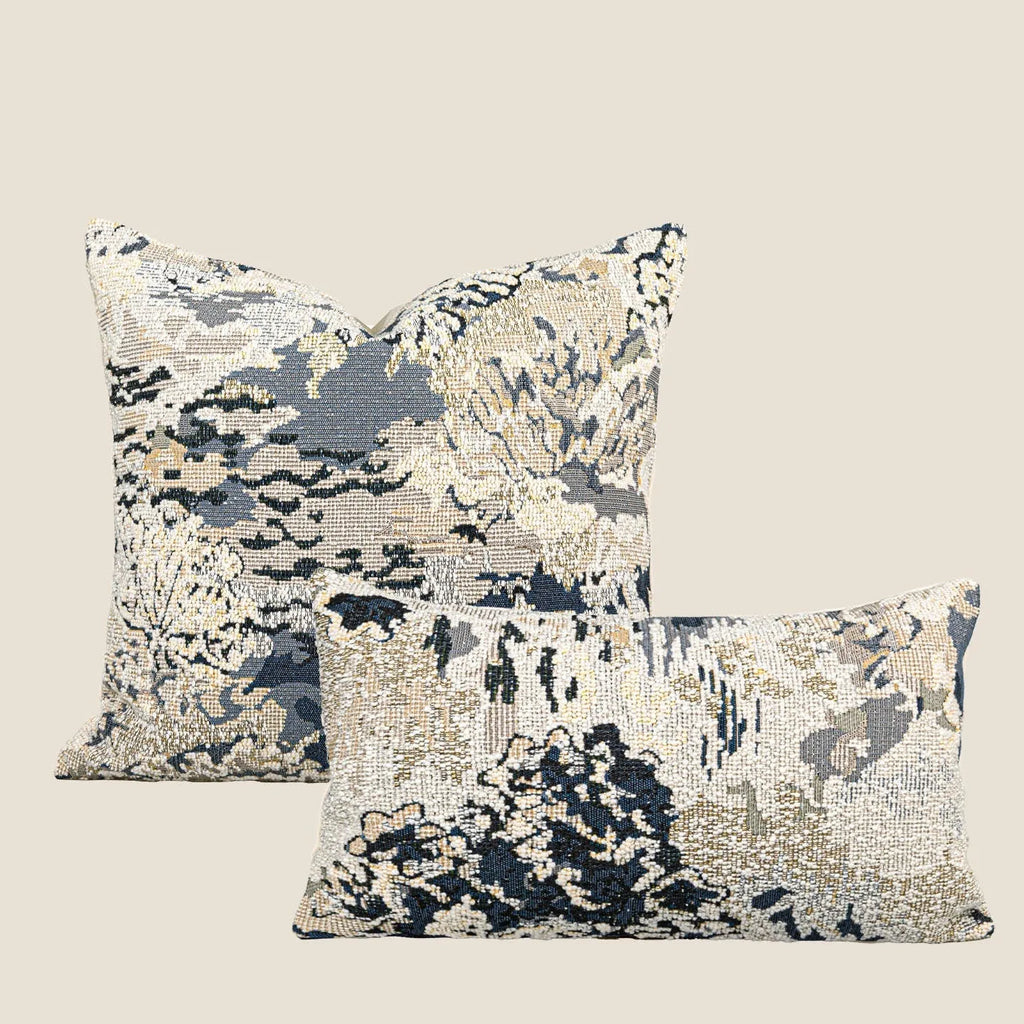 Blue abstract floral patterned decorative pillow on a sofa, showing square and rectangular sizes.