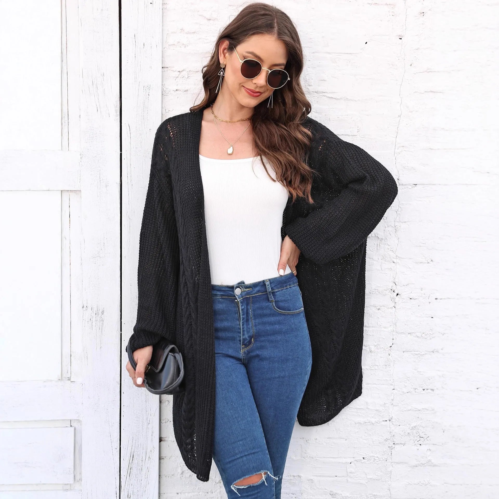 Women's loose-fitting solid colour acrylic sweater coat on a hanger