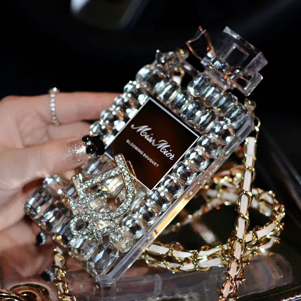 iPhone perfume bottle bow phone case in black with matte TPU shell and gold metal chain holding a perfume bottle charm.