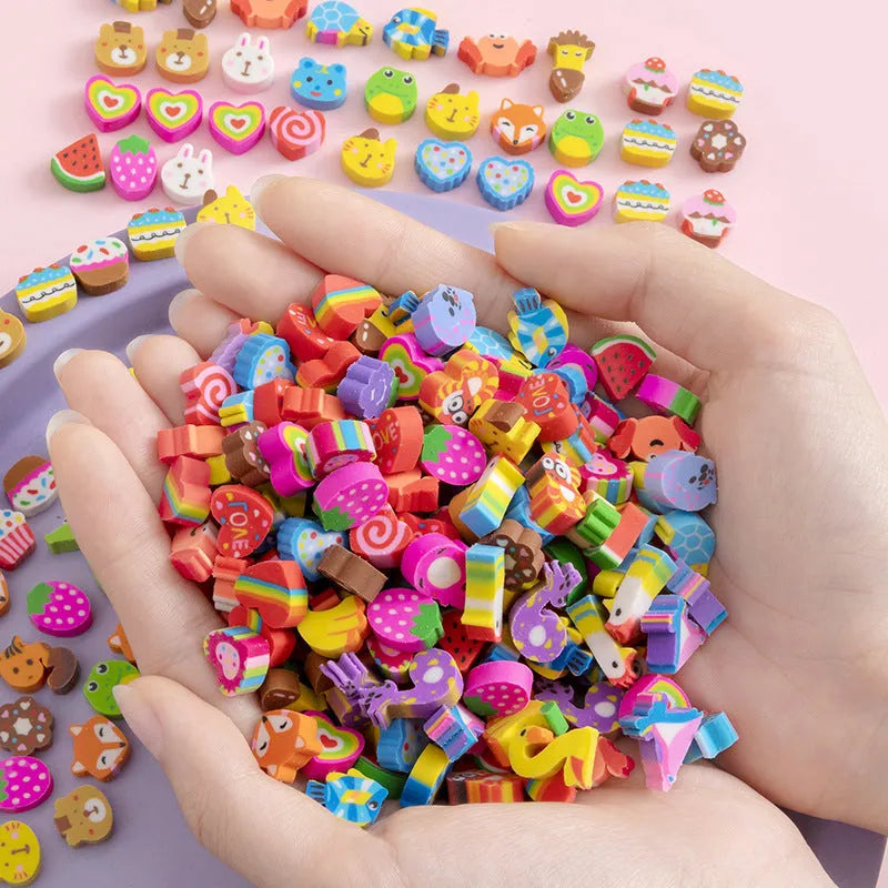 Assortment of 50 colourful mini cartoon erasers in shapes of fruits, animals, and cakes on a white background.