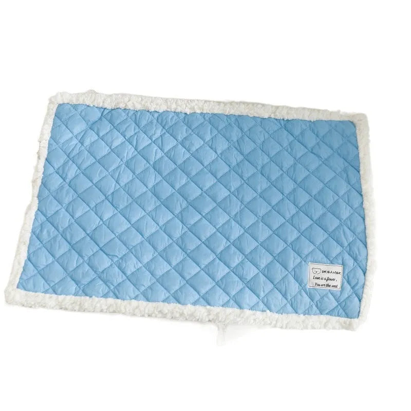 Quilted terry cloth cat blanket in blue, shown on a pet bed.