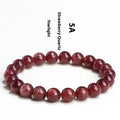 Natural cherry red strawberry quartz bracelet with geometric beads on a wrist