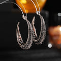 Women's large geometric copper hoop earrings in gold, silver, purple, green, or black.