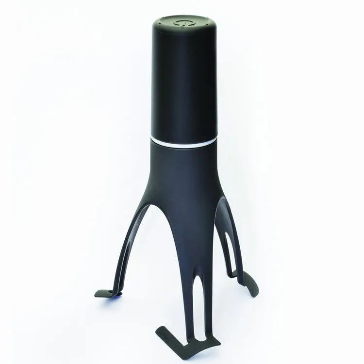 Green and grey automatic Stirr utensil for hands-free mixing in a cooking pot.
