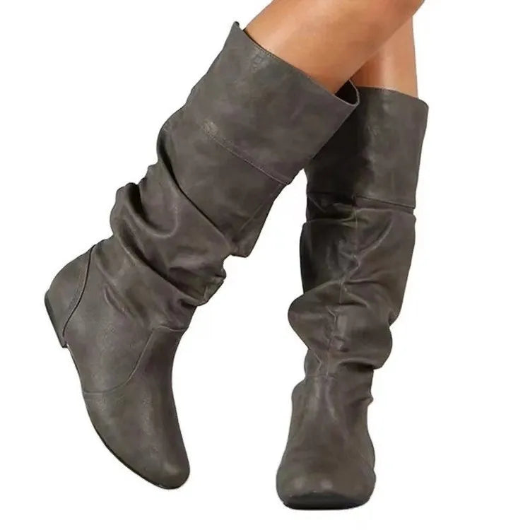 Women's flat knee-high slip-on boots in black with a round toe and rubber sole.