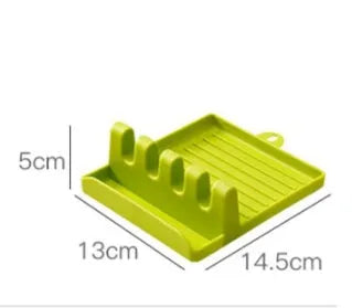 Green silicone kitchen utensil holder with four holes holding spatula, spoon, knife, and chopsticks on countertop