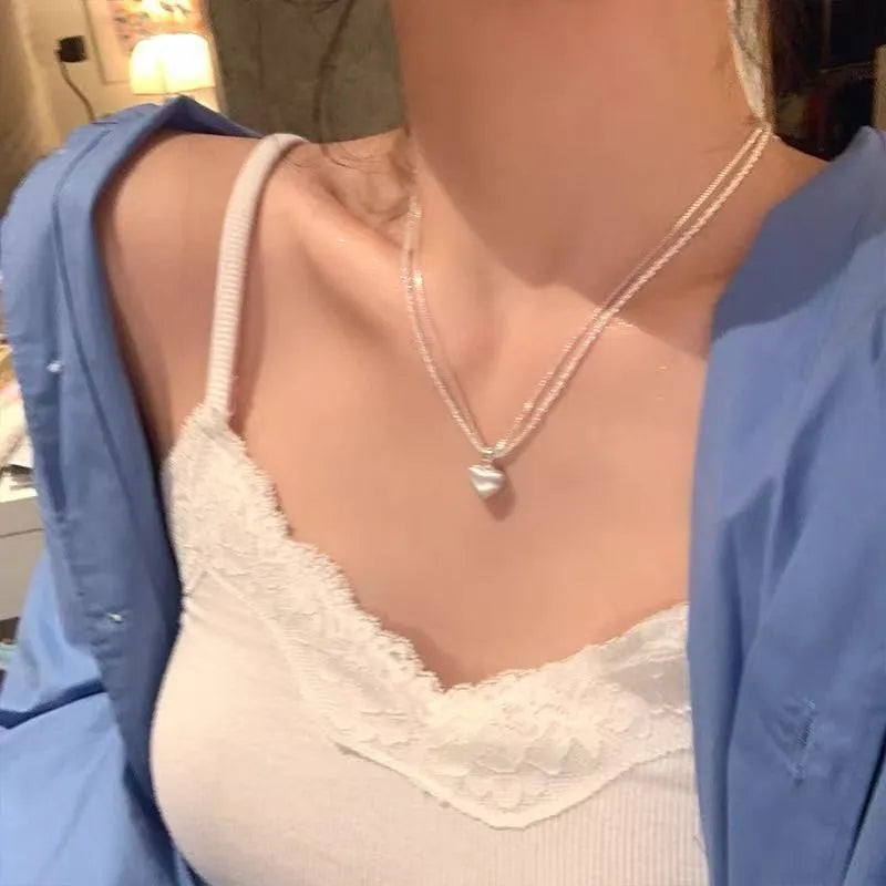 Women's brushed heart-shaped double-layer pendant necklace with adjustable chain on white background