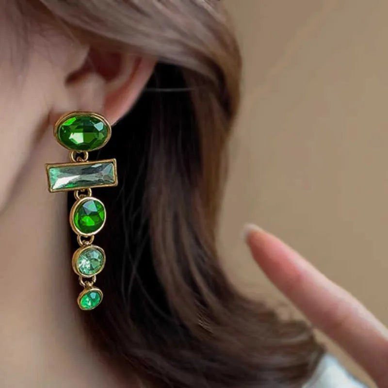 A pair of green gradient tassel earrings with a geometric shape and inlaid zircon detail.
