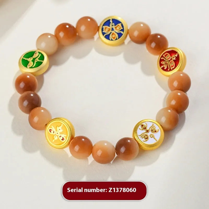 Yellow Bodhi seed bracelet with five directions geometry pattern on wooden surface