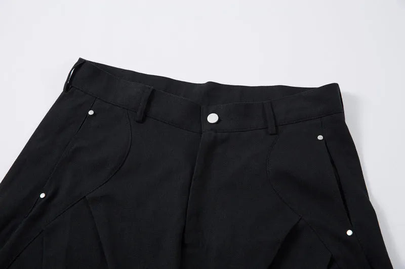 Man wearing black pleated wide-leg casual cotton trousers in a loose fit.