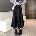 A slimming milky white corduroy A-line midi skirt with an elastic waistband laid flat.