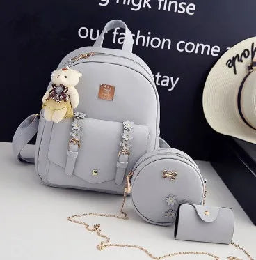 Women's three-piece PU leather bag set showing backpack, shoulder bag, and card holder with floral detailing
