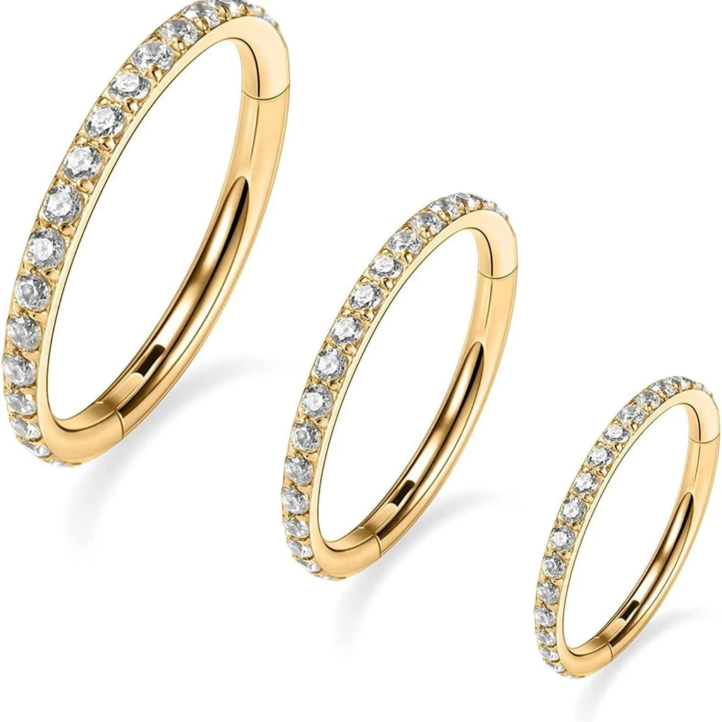 Stainless steel seamless nose ring with a small diamond on the front, shown in a gold finish.