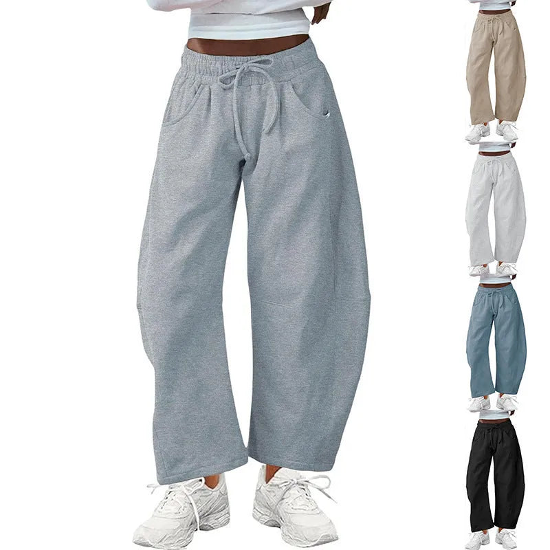 Women's loose cropped sweatpants with elastic drawstring waist in apricot colour showing side pockets and street fashion styling