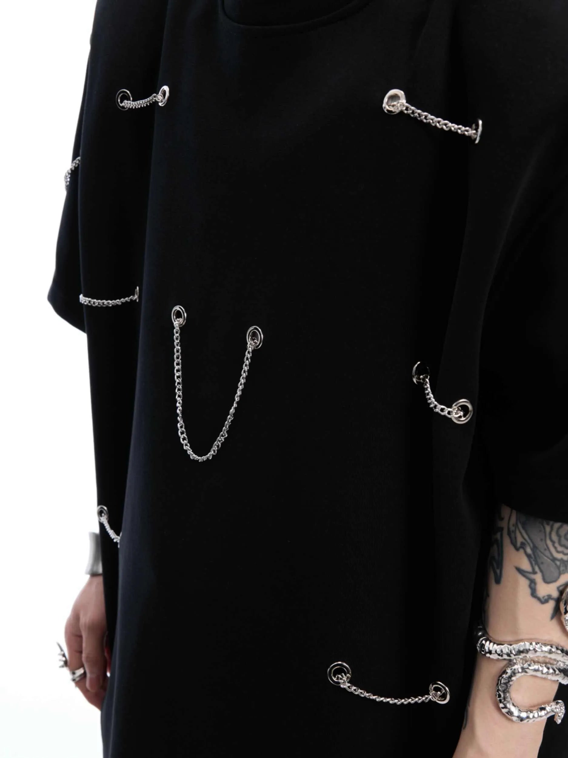 Black T-shirt with padded shoulders and metal chain detail on short sleeves