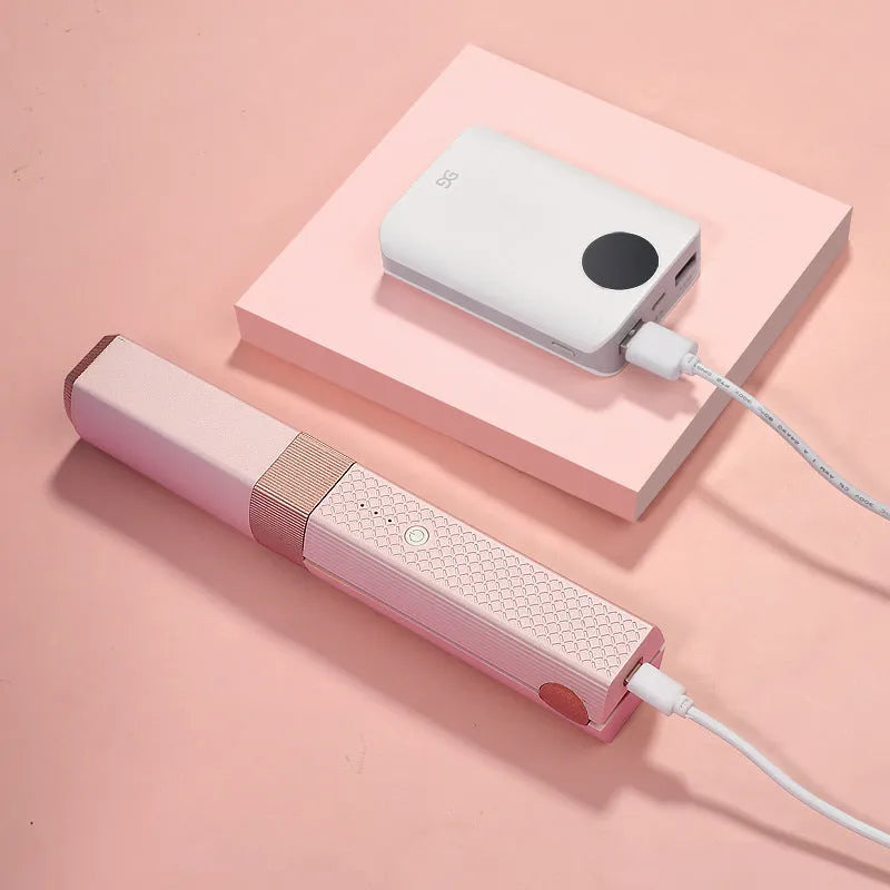 Pink and green mini cordless USB hair straightener and curler with ceramic plates.