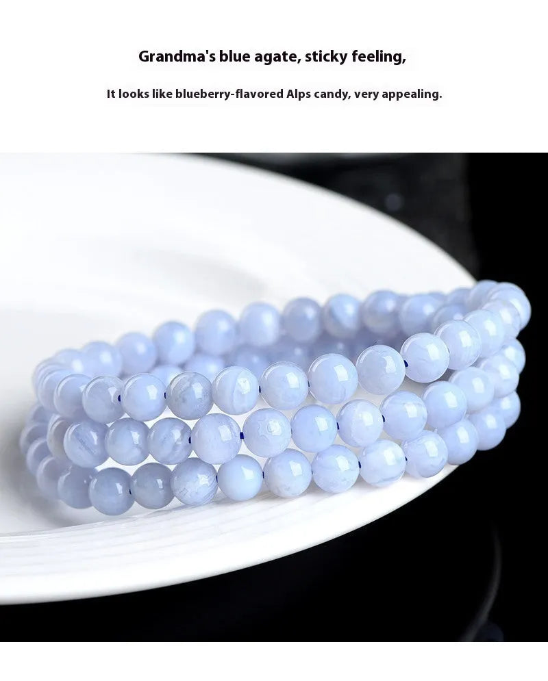Blue agate bracelet with multi-circle pattern and scattered striped beads on a wrist.