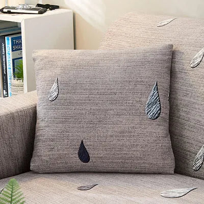 Geometric pattern stretch sofa slipcover and matching cushion cover on a double seat sofa.