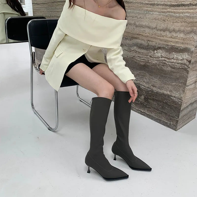 Black pointed toe women's boots with stiletto heel and back zipper, shown from the side.