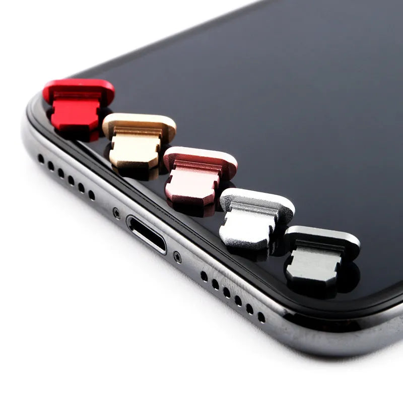 Aluminum alloy iPhone charging port dust plug in rose gold colour on a grey background.