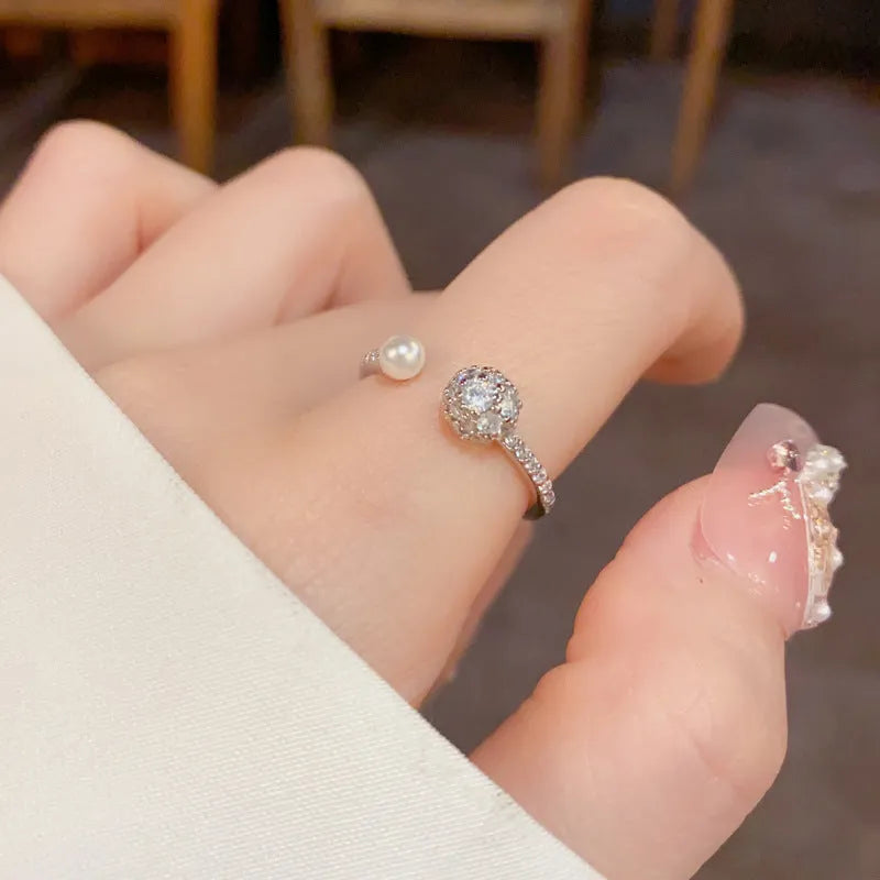 Minimalist open-end ring with round zircon stone on a geometric band in gold tone.