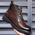 Black women's patent leather ankle boots with a low square heel and high cylinder shaft on a plain background.
