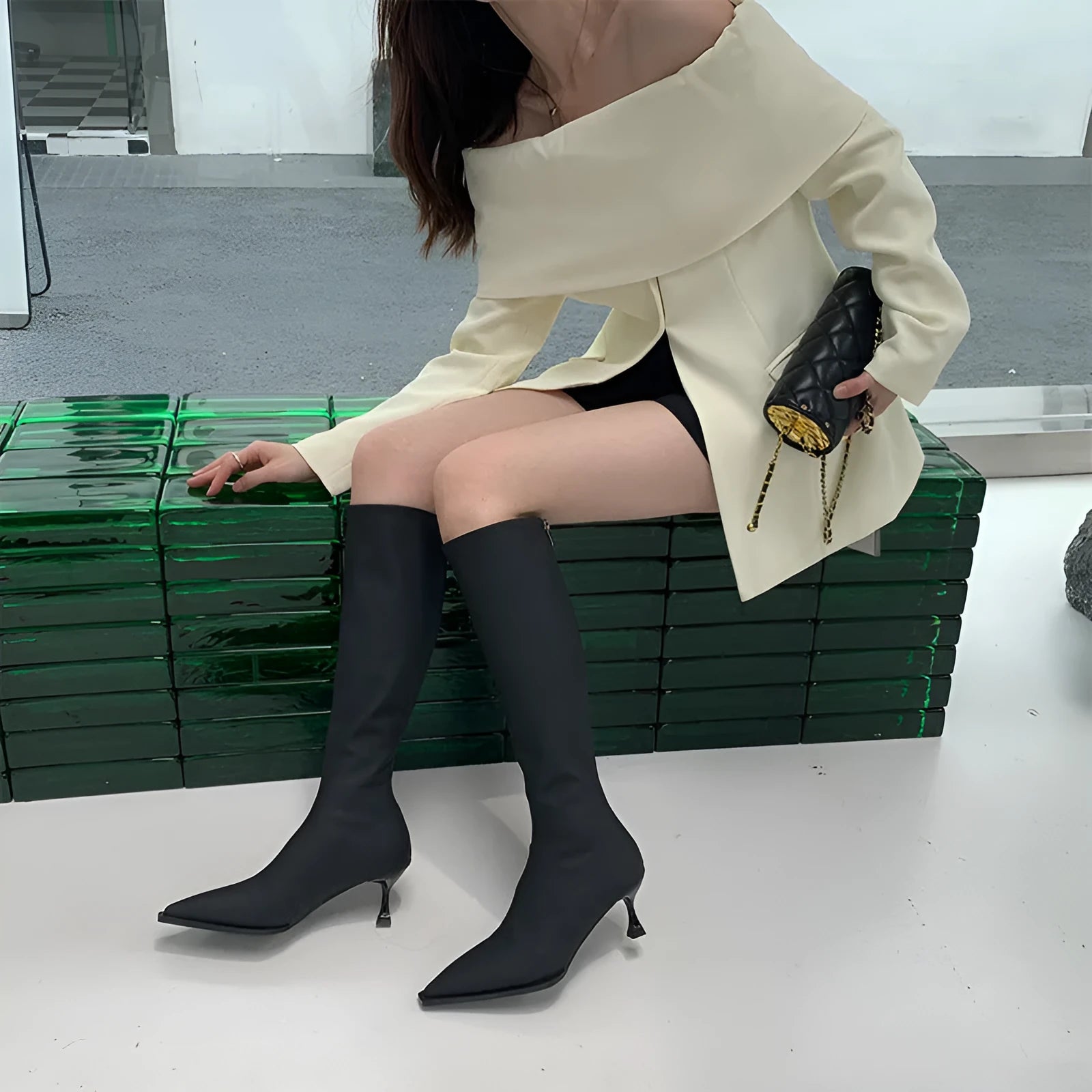 Black pointed toe women's boots with stiletto heel and back zipper, shown from the side.