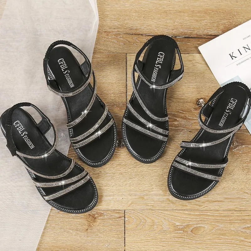 Women's flat silver sandals with round toe, rhinestone details, and an elastic strap.