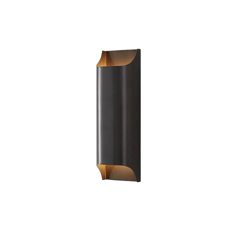 Minimalist copper wall lamp in black gold finish mounted beside a bed