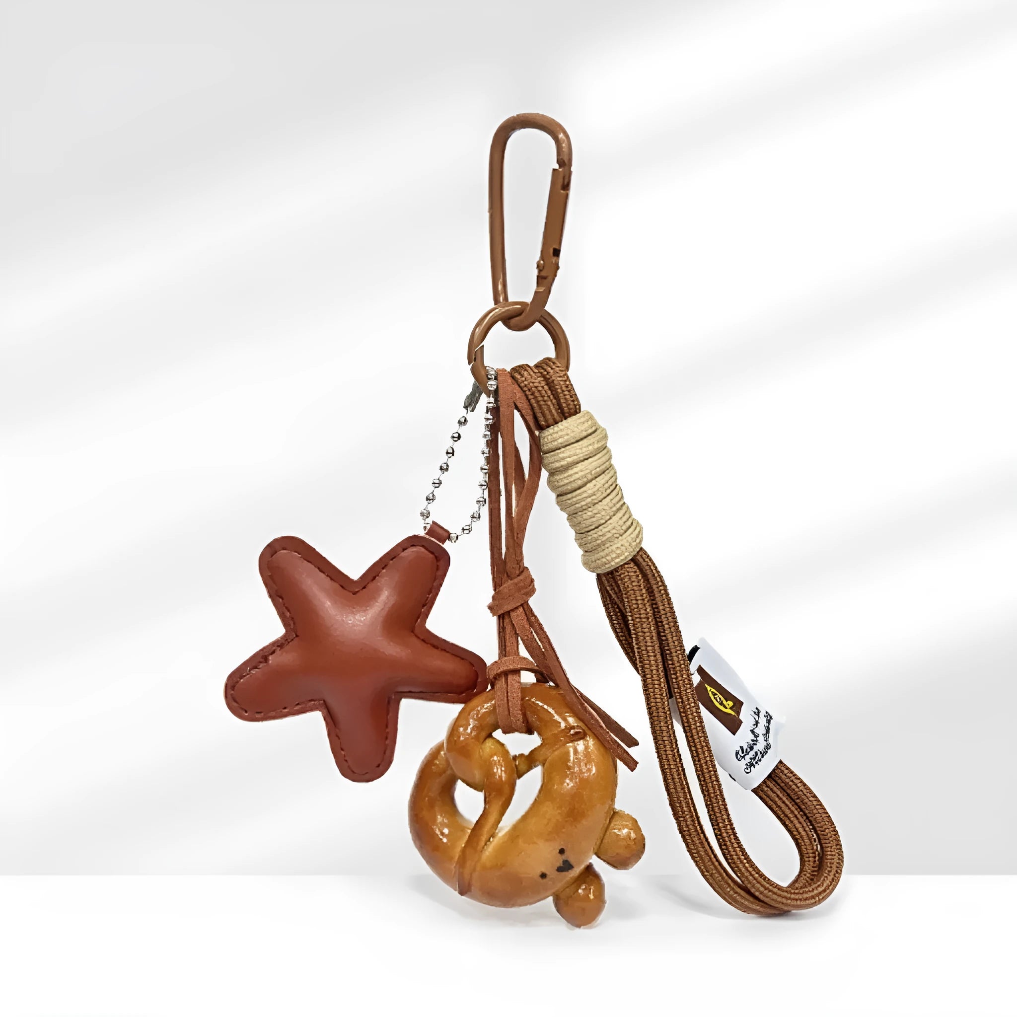 Handmade soda bread handbag charm pendant with cartoon croissant design and brown strap