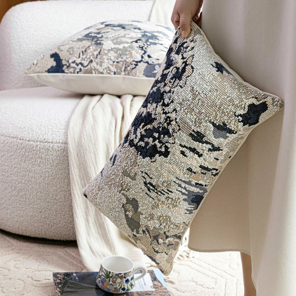 Blue abstract floral patterned decorative pillow on a sofa, showing square and rectangular sizes.