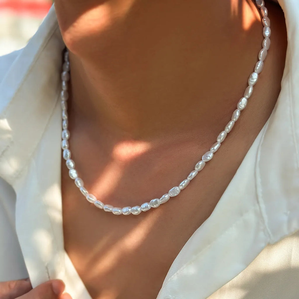 White U-shaped men's imitation pearl necklace with shellfish pendant on clavicle