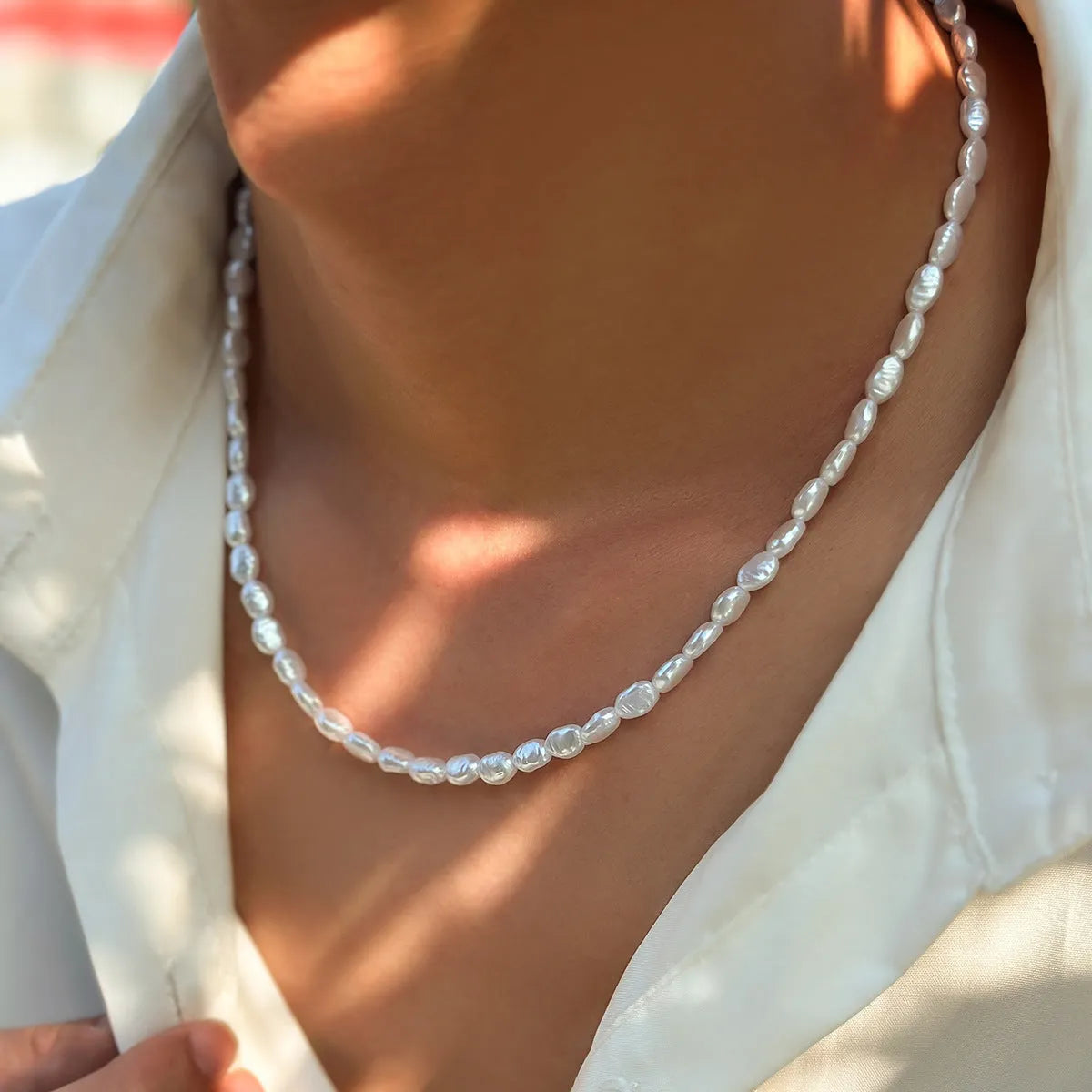 White U-shaped men's imitation pearl necklace with shellfish pendant on clavicle