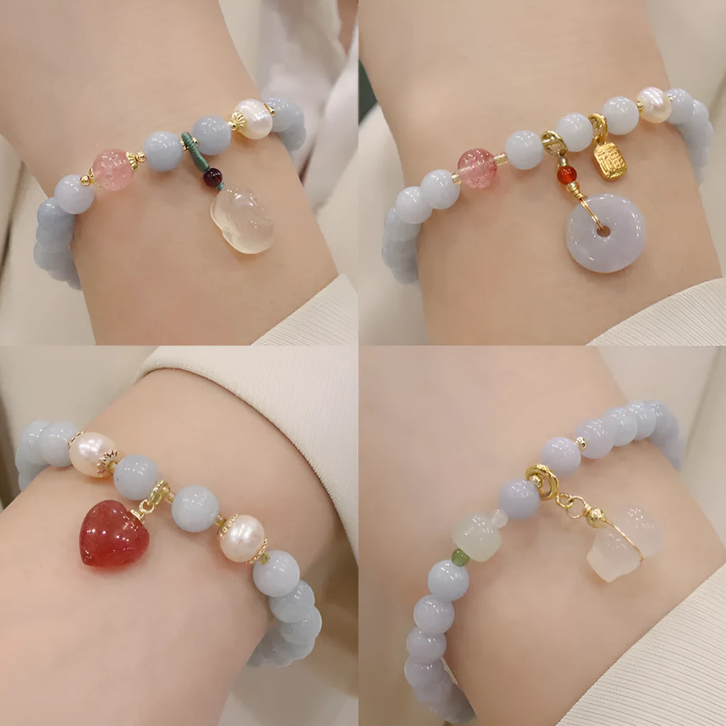 Gold plated bracelet with a detailed artificial crystal charm pendant on a woman's wrist.