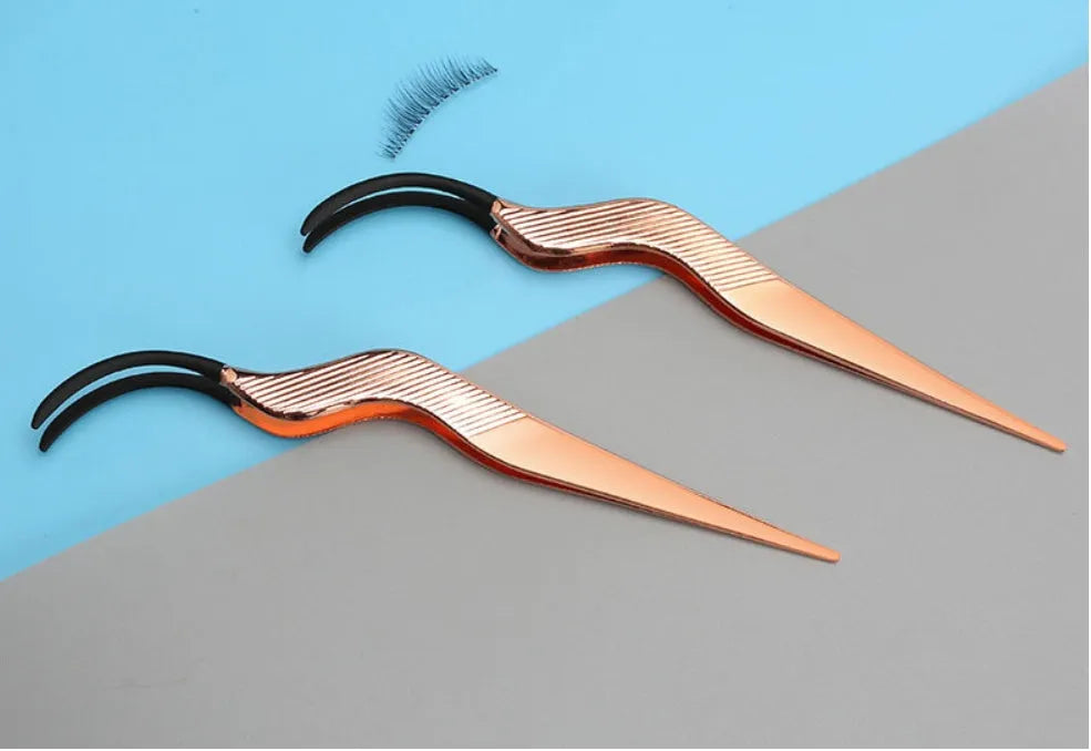 Rose gold metal false eyelash curler aid tool on plain background