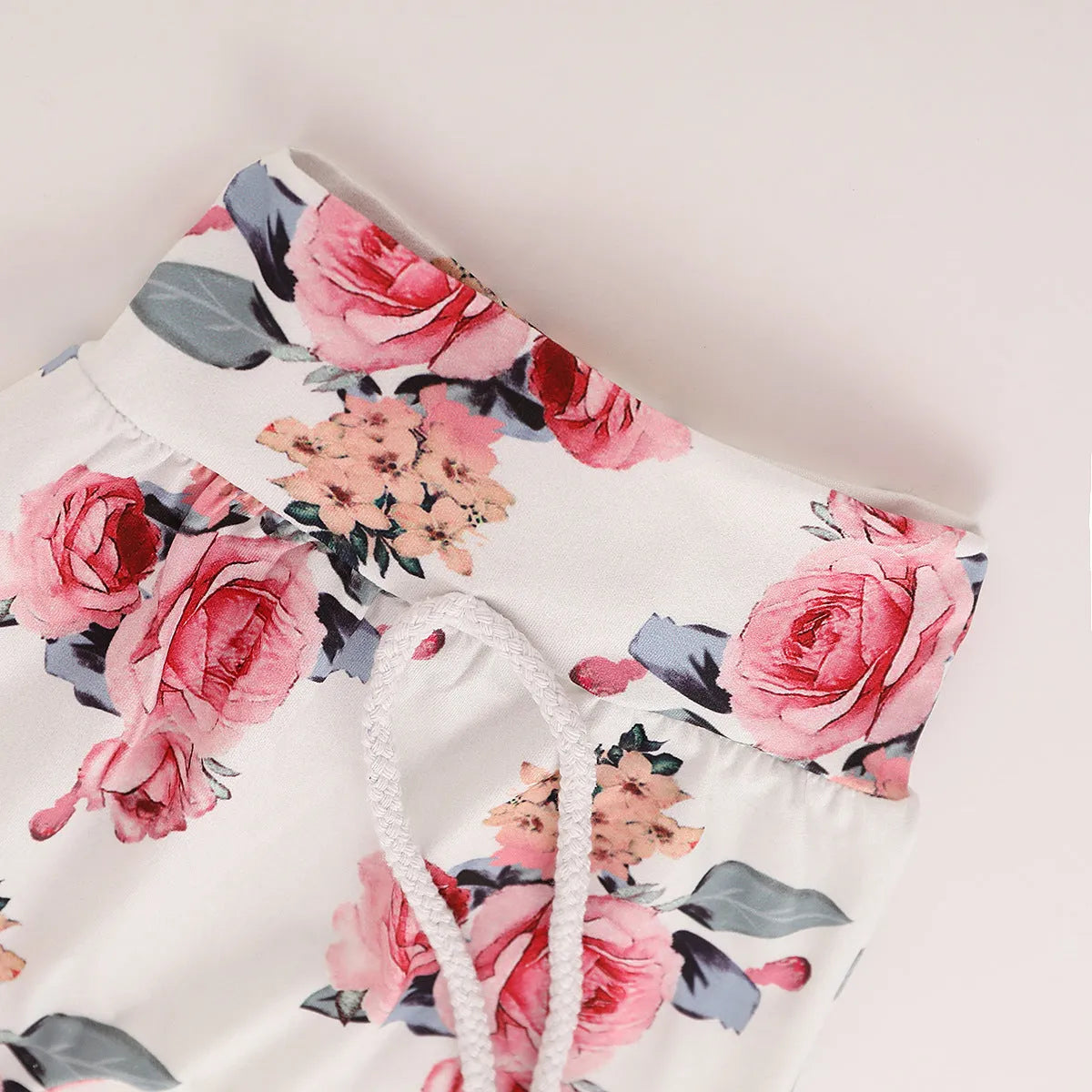White print hooded romper suit for baby girls made from soft cotton with long sleeves and trousers.
