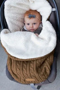 Envelope-style baby stroller sleeping bag in beige colour with thick filling, shown next to a pram.